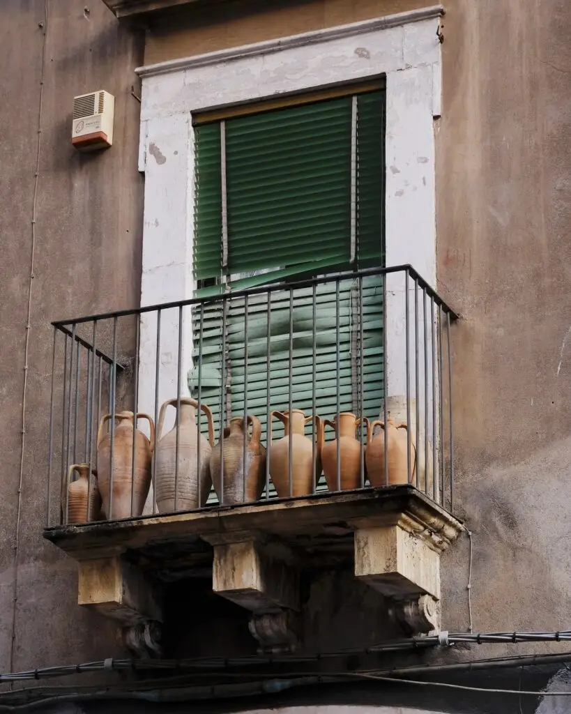 Old pots on the balcony on Via dei Crociferi in Catania
