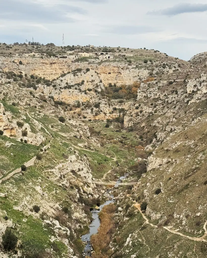 Suspension bridge crossing the rocky Gravina di Matera below the hiking trails