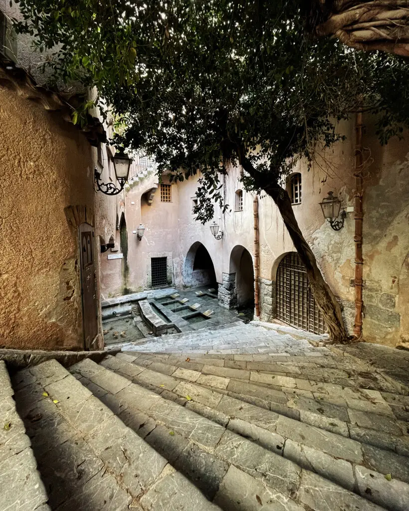 Stone steps and washing basins inside the medieval washhouse in Cefalù