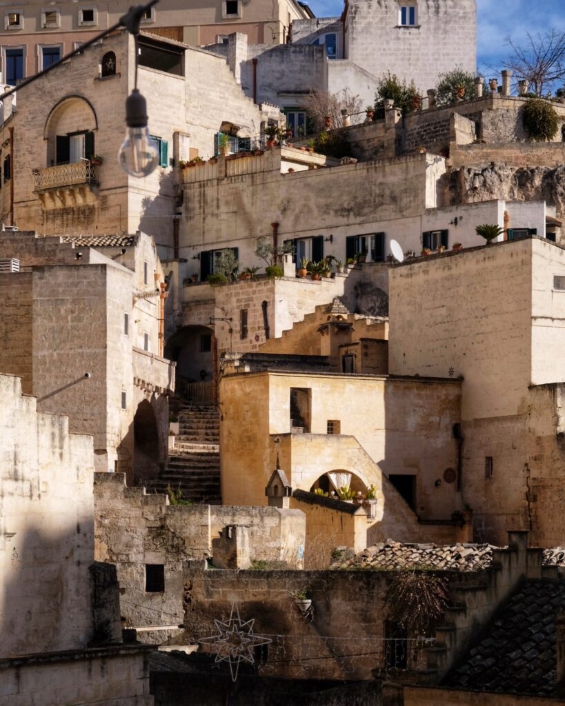 Sunlit stone houses and stairways in the Sassi of Matera